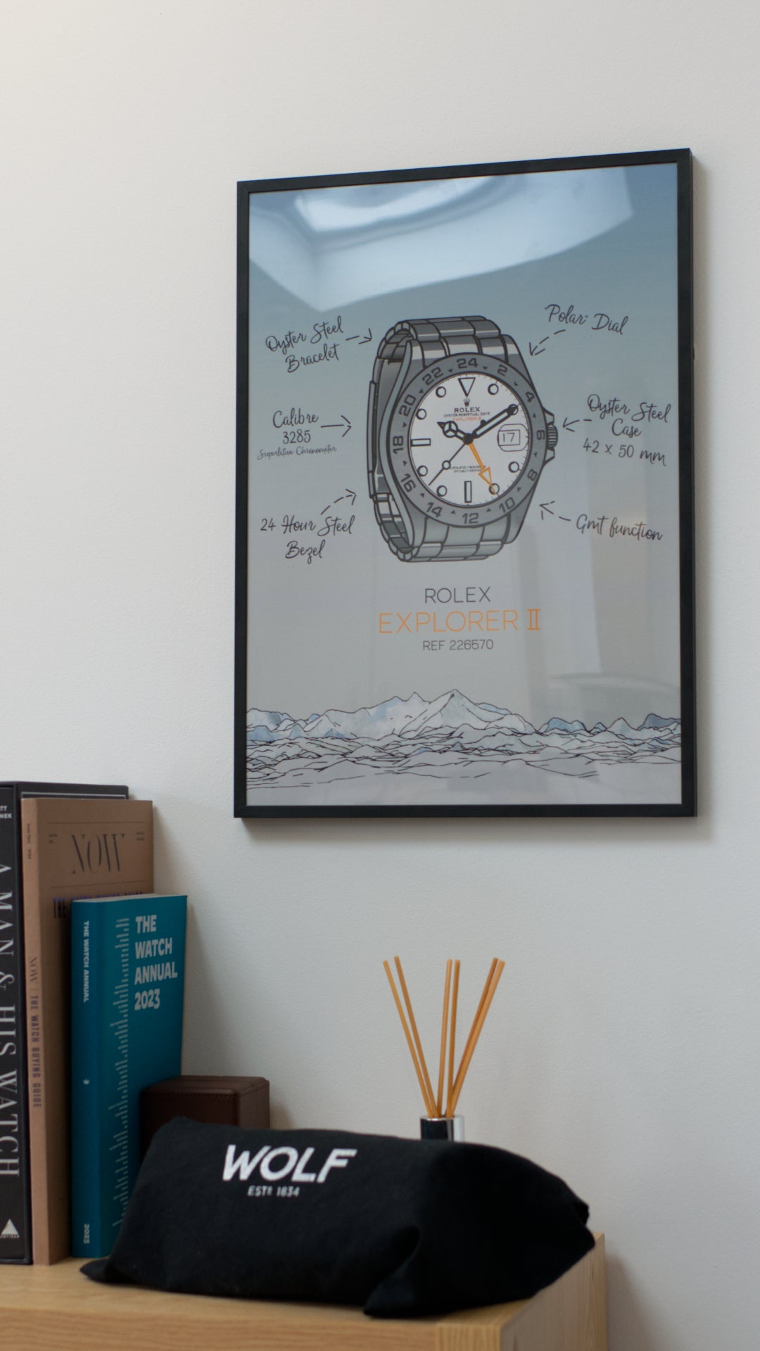 Rolex Explorer II Art Print displayed in a thin black frame, hung on a wall next to some books about watches.
An icon within the Rolex catalog and history, this latest reference, the 226570, is the perfect tool watch to wear when amongst vast mountain ranges.
These prints make the perfect gift idea for the watch collector in your life.
Printed on premium Giclée 308 (GSM) paper, your print will be gallery quality.
All prints are made to order and come with a certificate of authenticity.